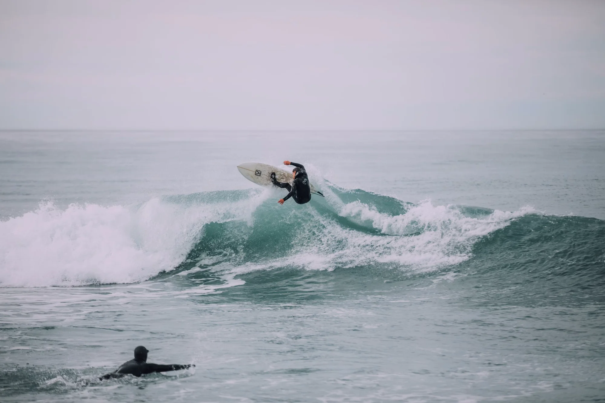 Person surft auf einer Welle im Meer